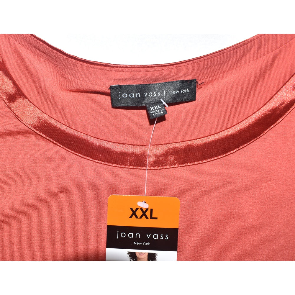 Clothing tag view on Joan Vass coral-colored garment on a white background