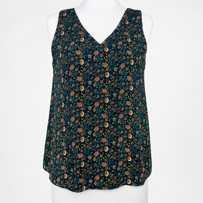 A sleeveless V-neck top with a dense floral and paisley print, displayed on a white mannequin torso against a plain white background.