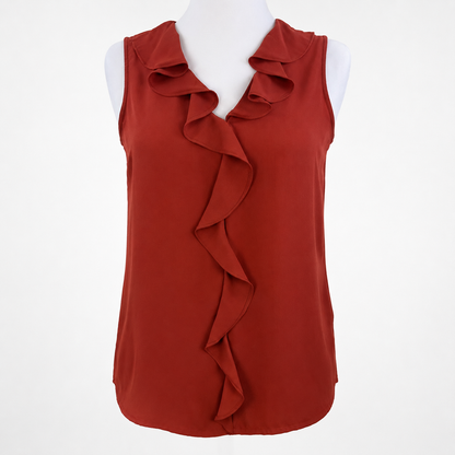 A rust red sleeveless blouse with a ruffled collar and a cascading ruffle down the front, displayed on a white mannequin torso against a white background.