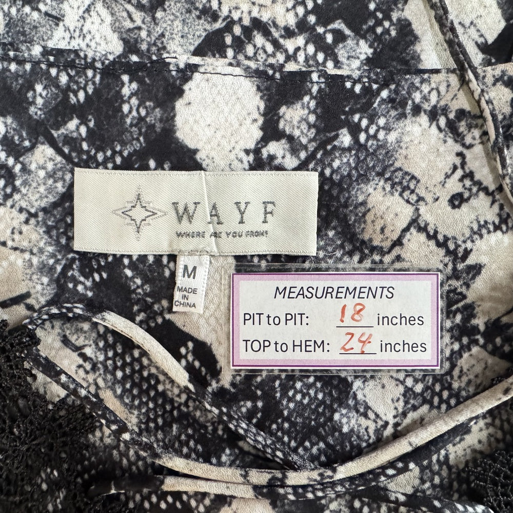 Clothing tag view of patterned fabric with 'WAYF' brand label and measurements