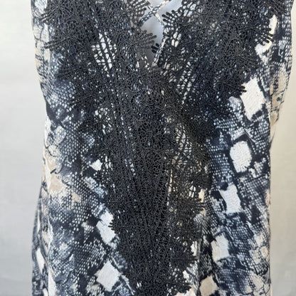 Front lower detail on Wayf camisole black lace garment with a patterned background