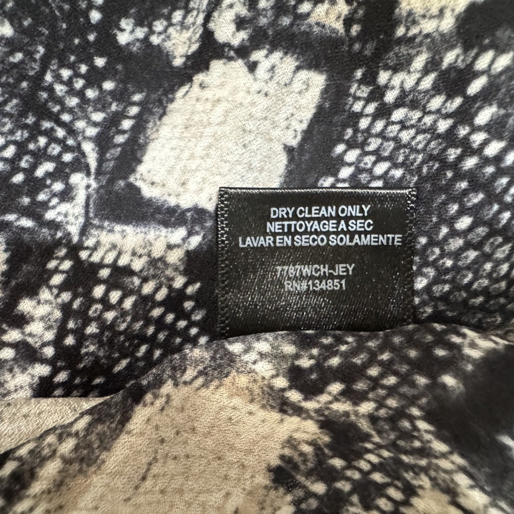 Clothing care tag view on Wayf top with a pattern and a care label on a textured background