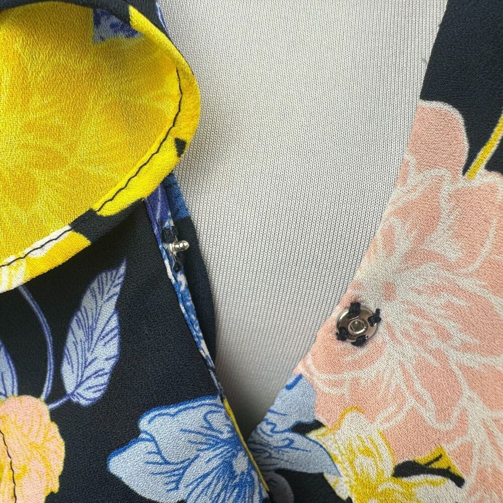 Blusa cruzada Banana Republic, talla S, negra con diseño floral y volantes, manga corta.