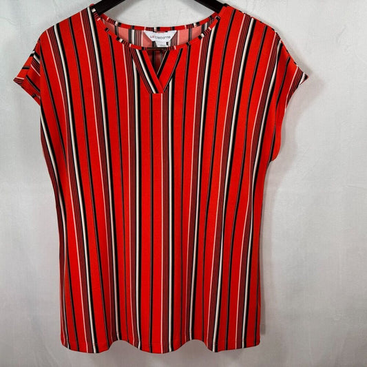 A red short-sleeve blouse with vertical black, white, and red stripes, hanging on a black hanger against a white fabric backdrop.