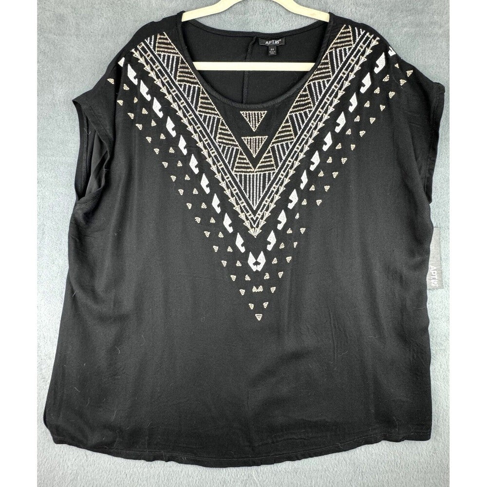 A black sleeveless top with a scoop neck, featuring a geometric white and silver pattern along the V-neckline, hanging on a wooden hanger against a gray textured background.