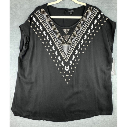 A black sleeveless top with a scoop neck, featuring a geometric white and silver pattern along the V-neckline, hanging on a wooden hanger against a gray textured background.