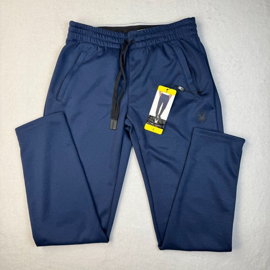 A pair of navy blue athletic jogger pants with an elastic waistband, black drawstring, side pockets, and a small spider logo on the left thigh, shown with a product tag on a light gray textured background.