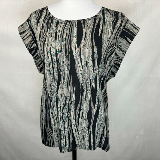 A short-sleeve top with an abstract wavy black, gray, and white pattern, displayed on a white mannequin torso against a light gray fabric backdrop.