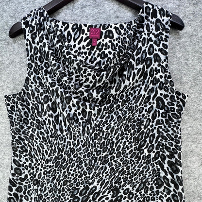 A sleeveless cowl-neck top with a black and white leopard print pattern, hanging on a black hanger against a gray textured background. A pink neck label shows the brand '112'.