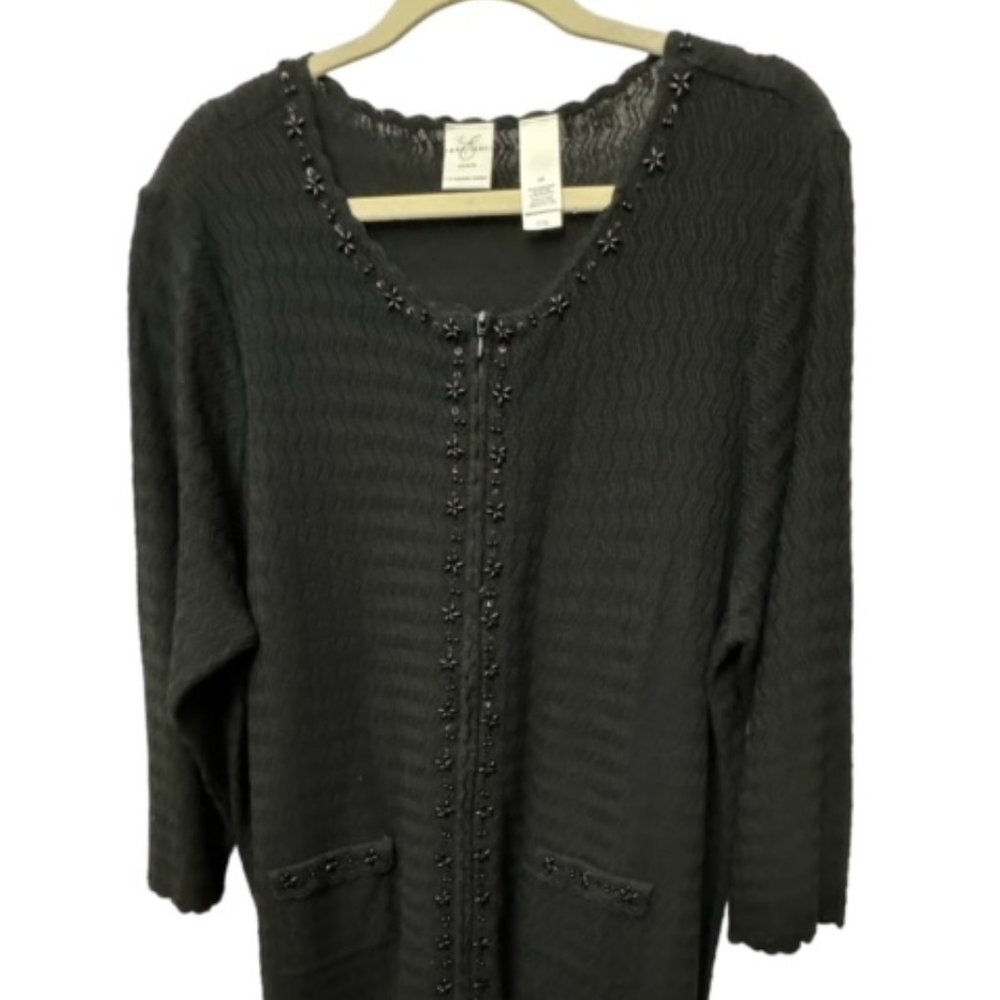 A dark charcoal gray knit cardigan sweater with scalloped edges and decorative bead trim, hanging on a wooden hanger against a white background.