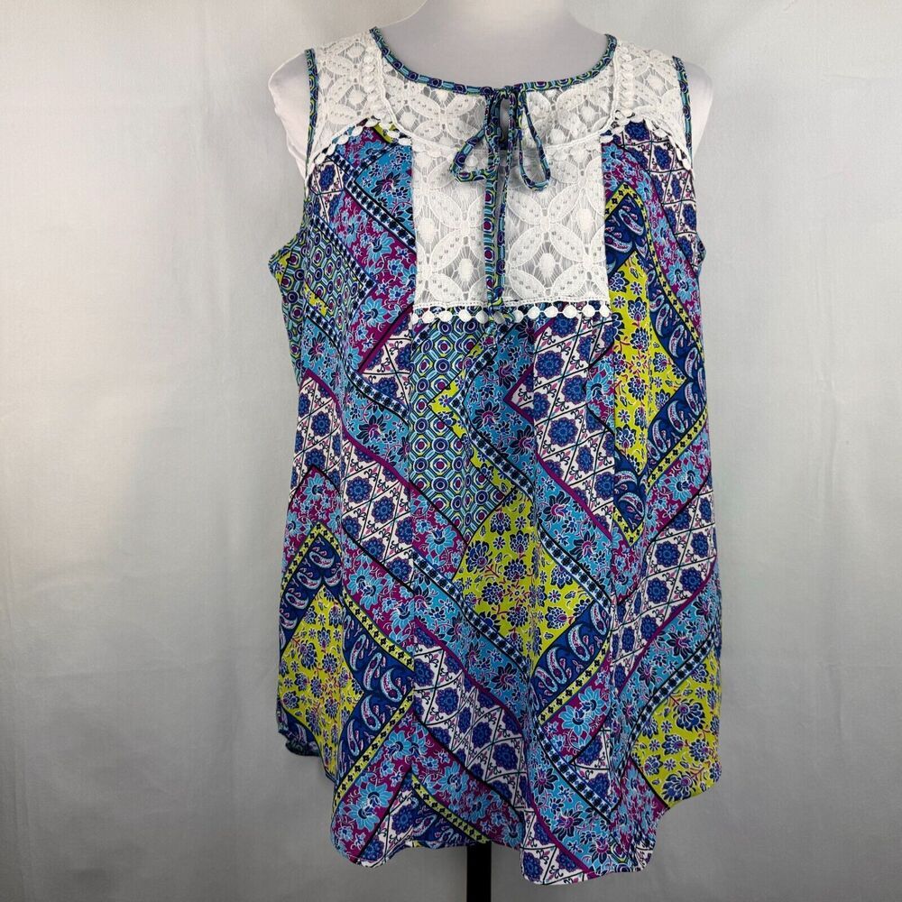 A sleeveless bohemian-style top with a white lace yoke and necktie, featuring a multicolor patchwork print of blue, purple, yellow, and pink geometric patterns, displayed on a mannequin against a light gray background.