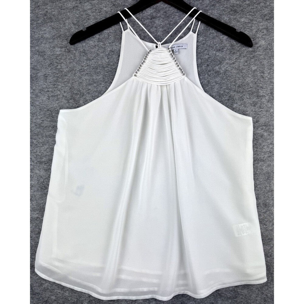 White sleeveless camisole top with thin straps and a lace-up back detail, hanging on a black hanger against a gray textured background.