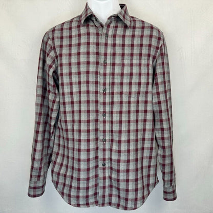 A long-sleeve button-up plaid shirt in a gray and burgundy checkered pattern, displayed on a white mannequin torso against a light gray textured background.