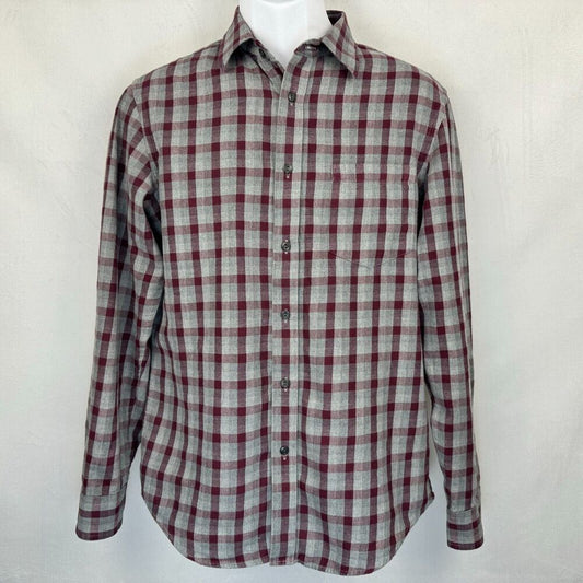 A long-sleeve button-up plaid shirt in a gray and burgundy checkered pattern, displayed on a white mannequin torso against a light gray textured background.