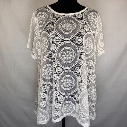 White lace short-sleeve top with circular floral mandala patterns, displayed on a black mannequin torso against a light gray fabric backdrop.