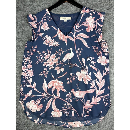 A sleeveless V-neck top with a navy blue background and a pink and white floral, bird, and leaf print, laid flat on a black hanger against a gray textured background.