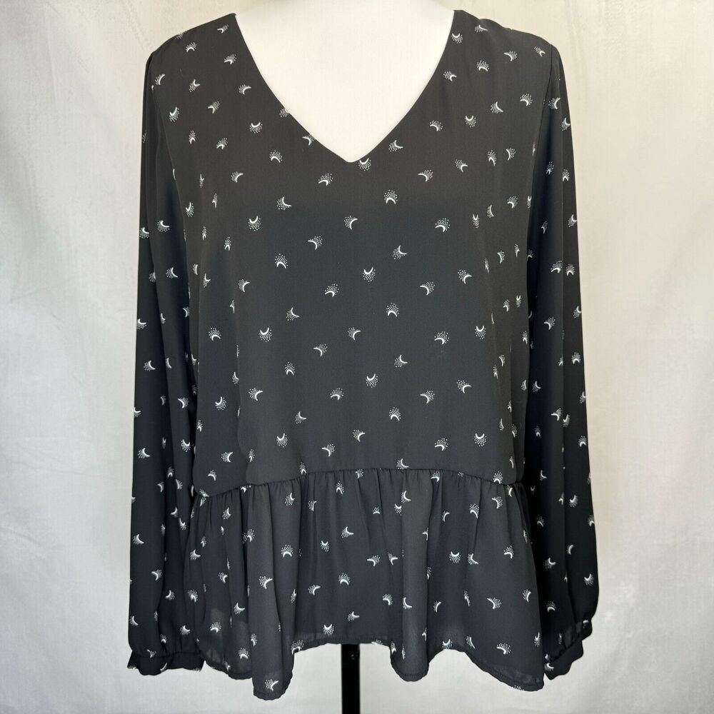 A black long-sleeve blouse with a small white bird pattern, displayed on a white dress form against a light gray fabric backdrop.
