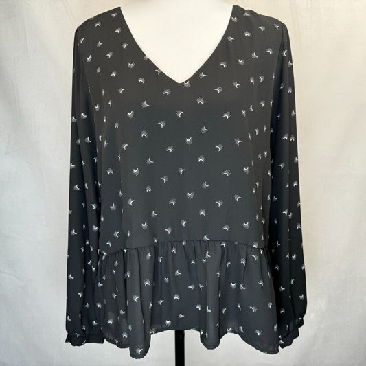 A black long-sleeve blouse with a small white bird pattern, displayed on a white dress form against a light gray fabric backdrop.