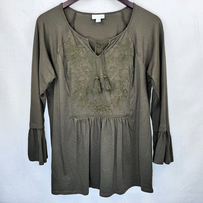 An olive green long-sleeve tunic top with a lace-up neckline and embroidered chest detailing, hanging on a dark hanger against a light gray background.