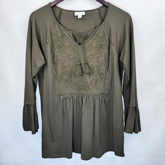 An olive green long-sleeve tunic top with a lace-up neckline and embroidered chest detailing, hanging on a dark hanger against a light gray background.