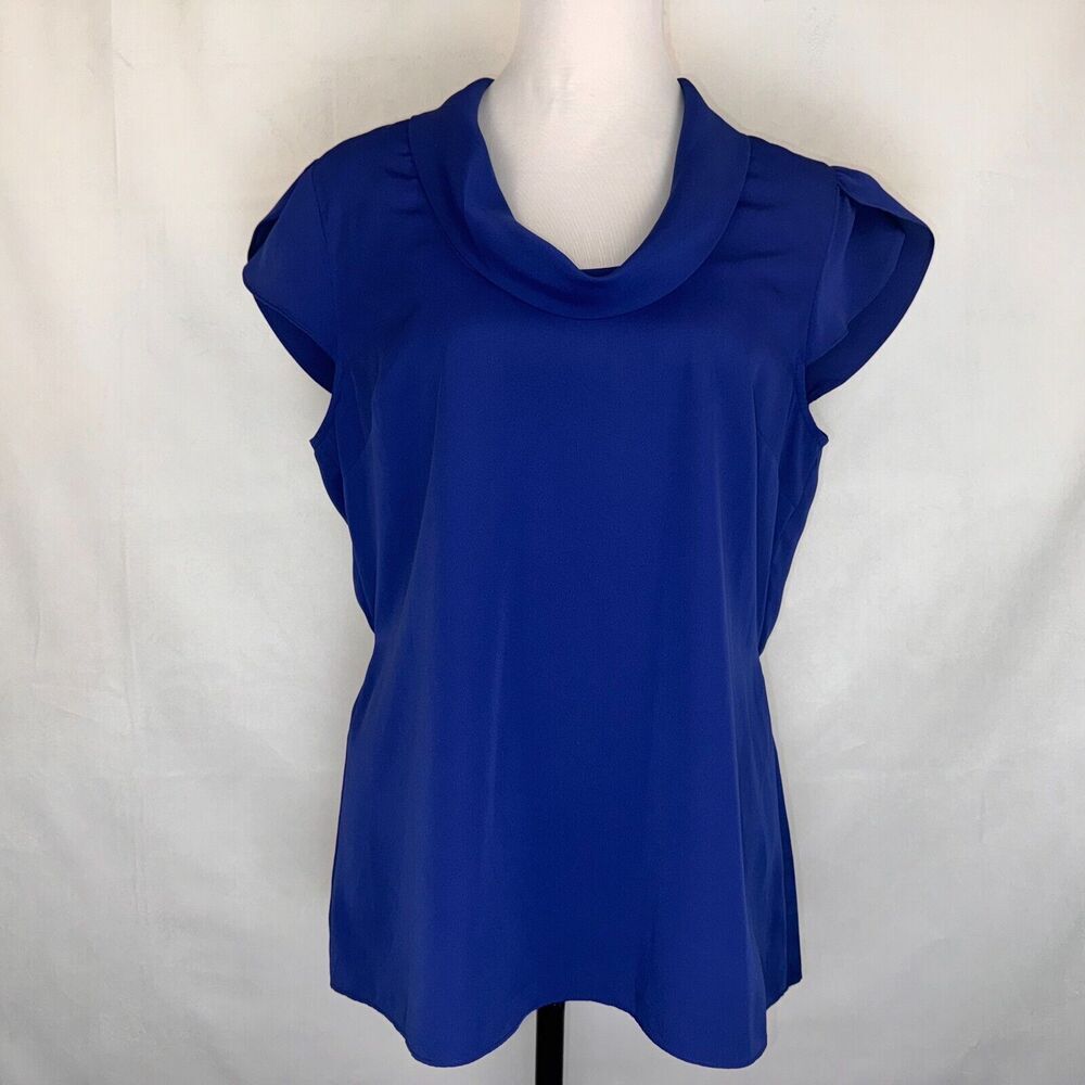 A royal blue short-sleeve top with a draped cowl neckline, displayed on a white mannequin torso against a white fabric backdrop.