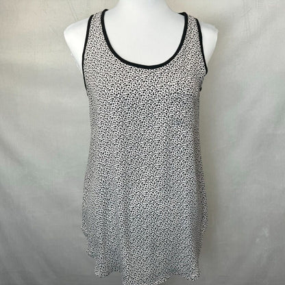 A sleeveless scoop-neck tank top with a black and white micro-dot pattern and black trim, displayed on a white mannequin torso against a light gray fabric backdrop.