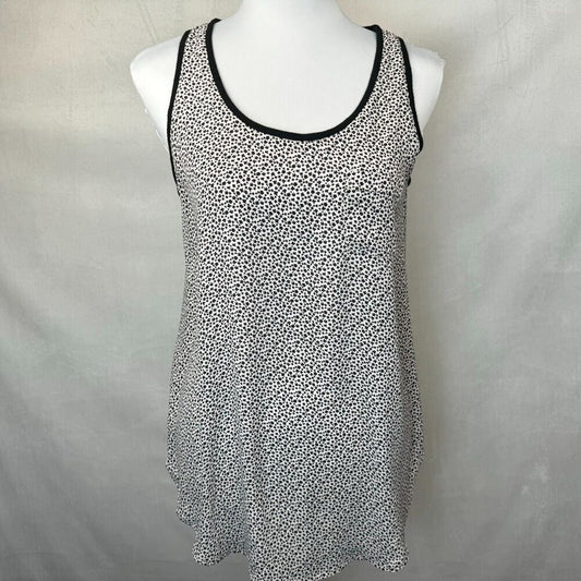 A sleeveless scoop-neck tank top with a black and white micro-dot pattern and black trim, displayed on a white mannequin torso against a light gray fabric backdrop.