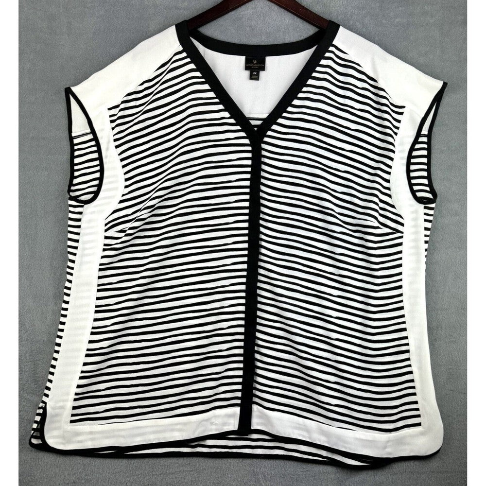 A sleeveless knit vest with a black and white horizontal stripe pattern, black trim, and a V-neckline, hanging on a dark wooden hanger against a gray background.