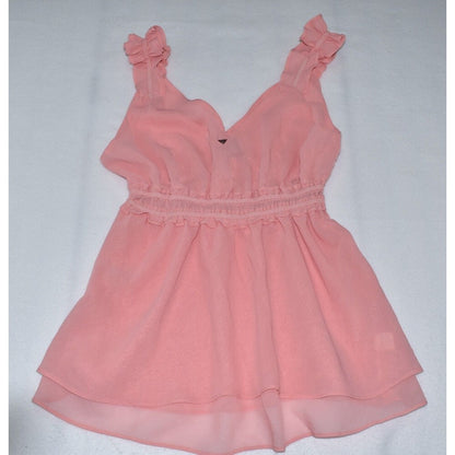 A light pink sleeveless dress with ruffled shoulder straps, a smocked waist, and a layered skirt, laid flat on a white background.