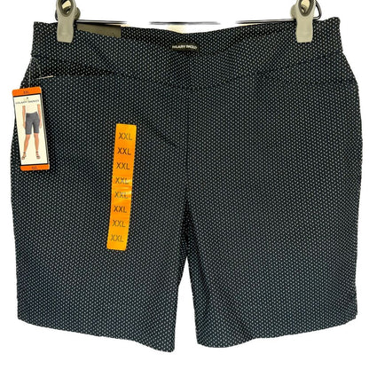 A pair of women's black shorts with a small white polka dot pattern, hanging from silver metal clips. The shorts still have their retail tags attached, including a yellow size tag indicating XXL and a brand tag that reads 'SILK CITY PARIS'.