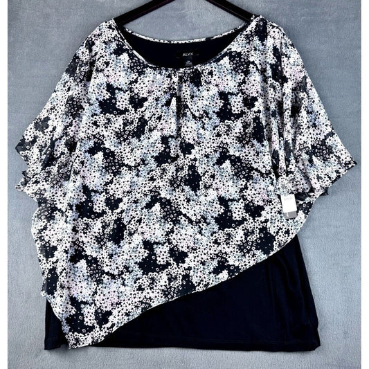 A women's short-sleeve top with a black and white floral print, layered over a solid black undergarment or skirt, displayed on a black hanger against a gray textured background.