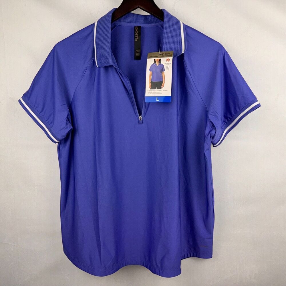 A royal blue short-sleeve polo shirt with white piping on the collar and sleeve cuffs, hanging on a dark wooden hanger against a light gray fabric backdrop. The shirt has a half-zip collar and is still attached to its retail hangtag.