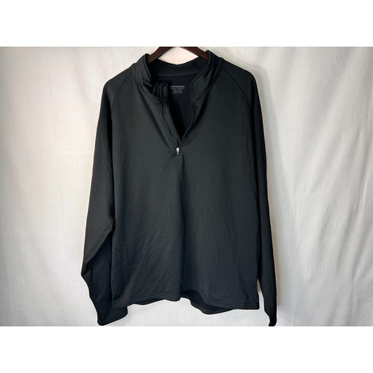 A black long-sleeve quarter-zip pullover top hanging on a wooden hanger against a white fabric backdrop.