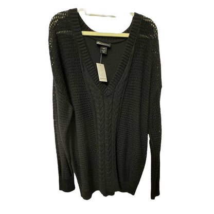 A black knit sweater with a V-neck and textured cable and open-knit patterns, hanging on a wooden hanger against a white background.