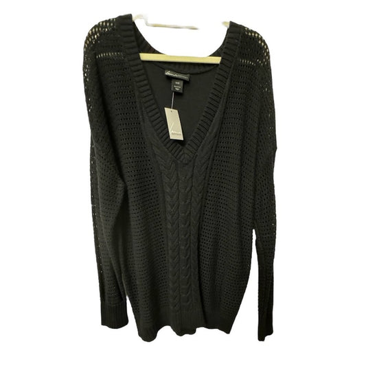 A black knit sweater with a V-neck and textured cable and open-knit patterns, hanging on a wooden hanger against a white background.