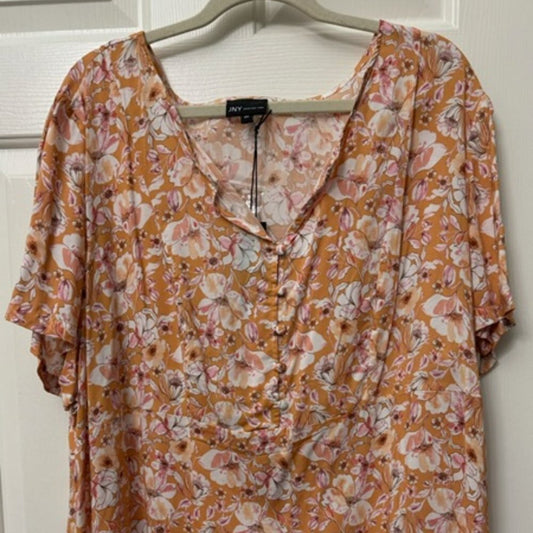 A short-sleeve V-neck blouse with a button-up front, featuring an all-over floral pattern in orange, pink, and white, hanging on a hanger against a white paneled door.