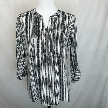 A black and white vertically striped button-up blouse with three-quarter sleeves, displayed on a white mannequin torso against a light gray fabric backdrop.
