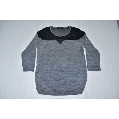 A women's long-sleeve knit top with a heather gray body, a black yoke across the shoulders, and a V-neckline, laid flat on a light gray surface.