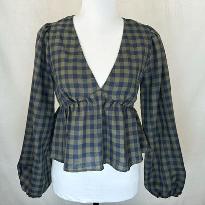 A women's long-sleeve blouse with a blue and olive green plaid pattern, featuring a wrap-style V-neckline, gathered waist, and balloon sleeves, displayed on a white mannequin torso.