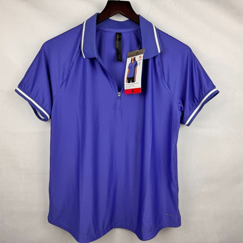 A royal blue short-sleeve polo shirt with white piping on the collar and sleeve cuffs, hanging on a dark wooden hanger against a light gray fabric backdrop. A hangtag is attached to the collar.