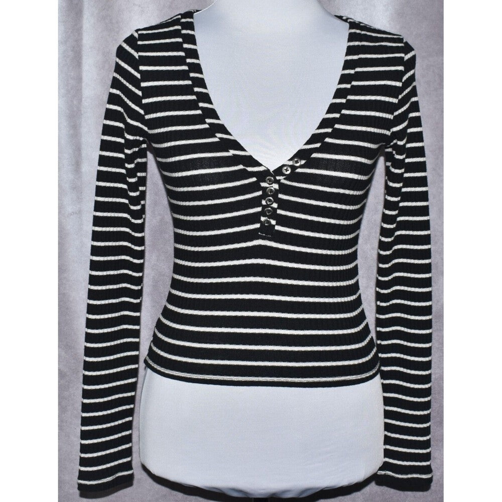 A black and white horizontally striped long-sleeve henley top displayed on a white mannequin torso against a gray curtain background.