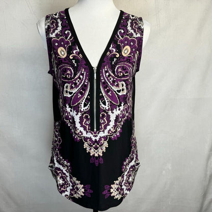 A sleeveless black V-neck top with a purple and white paisley pattern, displayed on a white mannequin torso against a light gray fabric backdrop.