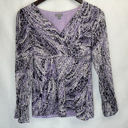 A women's long-sleeve wrap-style blouse with a textured, marled pattern in lavender, black, and white, hanging on a dark wooden hanger against a light gray fabric backdrop.