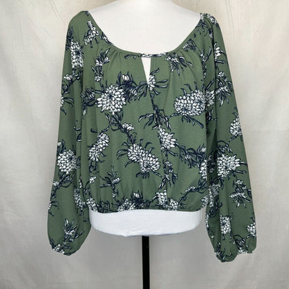 An olive green long-sleeve blouse with a white and navy floral print, displayed on a white mannequin torso against a neutral light gray fabric backdrop.