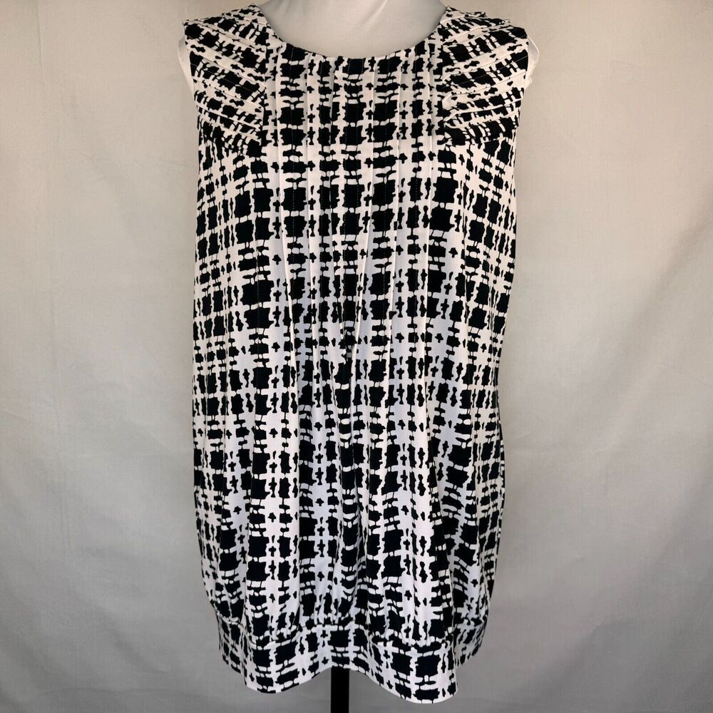 A sleeveless black and white tweed plaid dress displayed on a white mannequin torso against a light gray fabric backdrop.