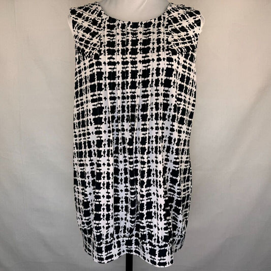 A sleeveless black and white tweed plaid dress displayed on a white mannequin torso against a light gray fabric backdrop.