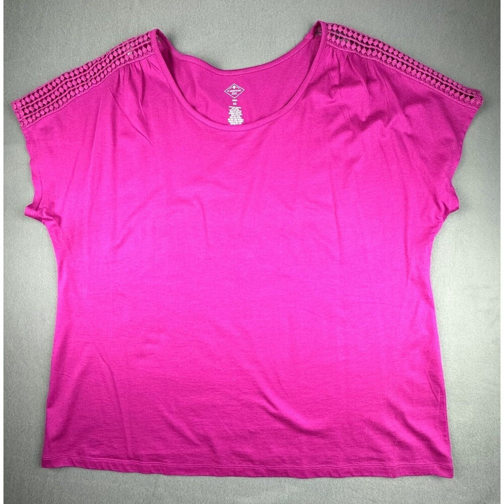 A bright pink short-sleeve top with textured crochet trim along the shoulders, laid flat on a gray background.