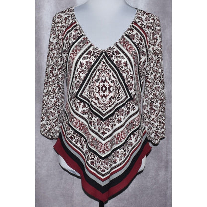 A women's long-sleeve V-neck top displayed on a mannequin torso, featuring a complex geometric and floral mandala pattern in black, white, and burgundy red.