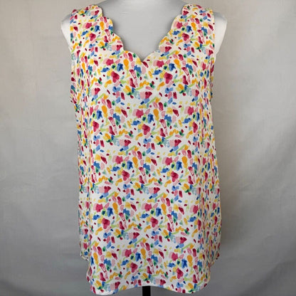 A sleeveless white top with a colorful abstract watercolor print, displayed on a mannequin torso against a neutral gray background.