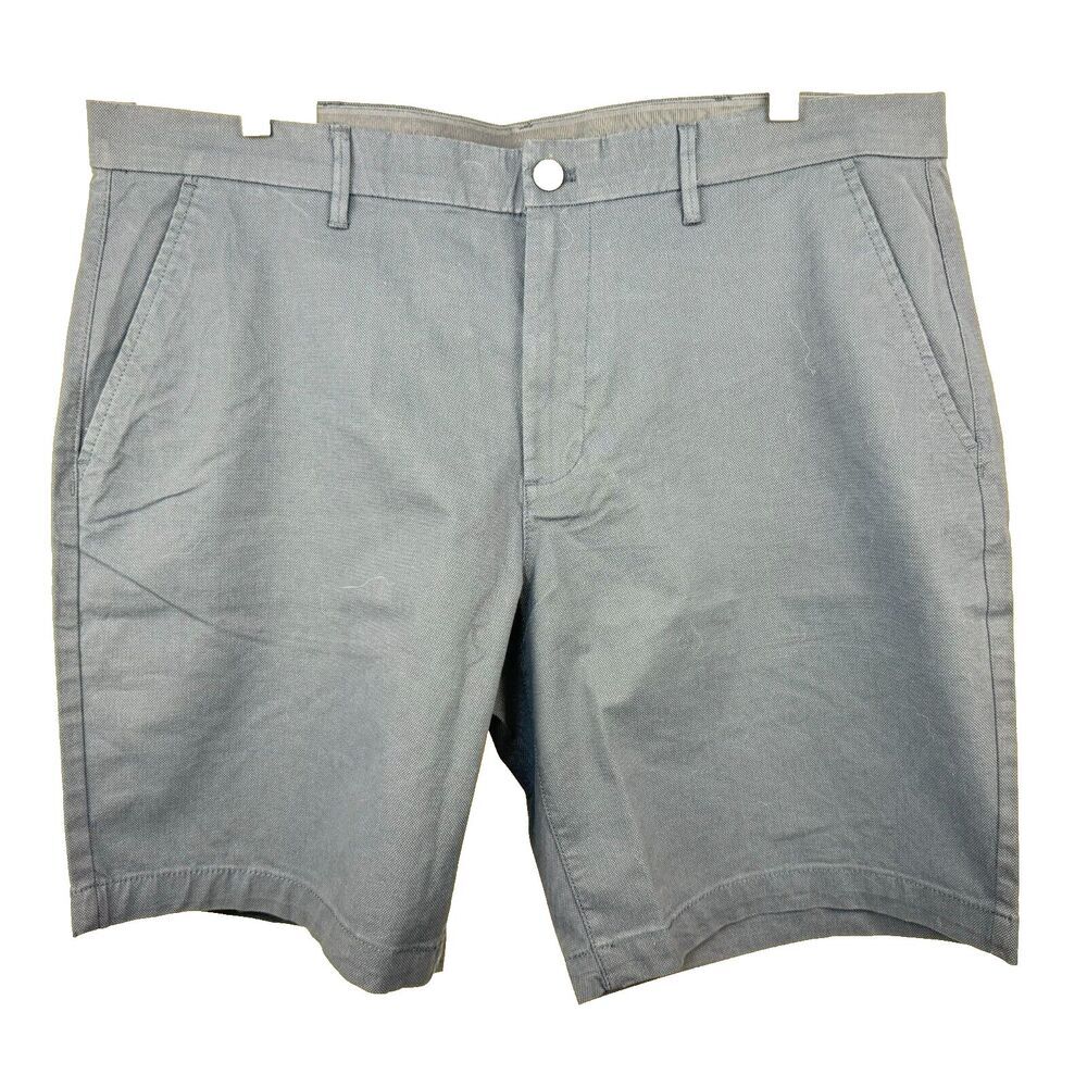 A pair of light gray chino shorts with belt loops, a button closure, and side pockets, shown flat against a white background.